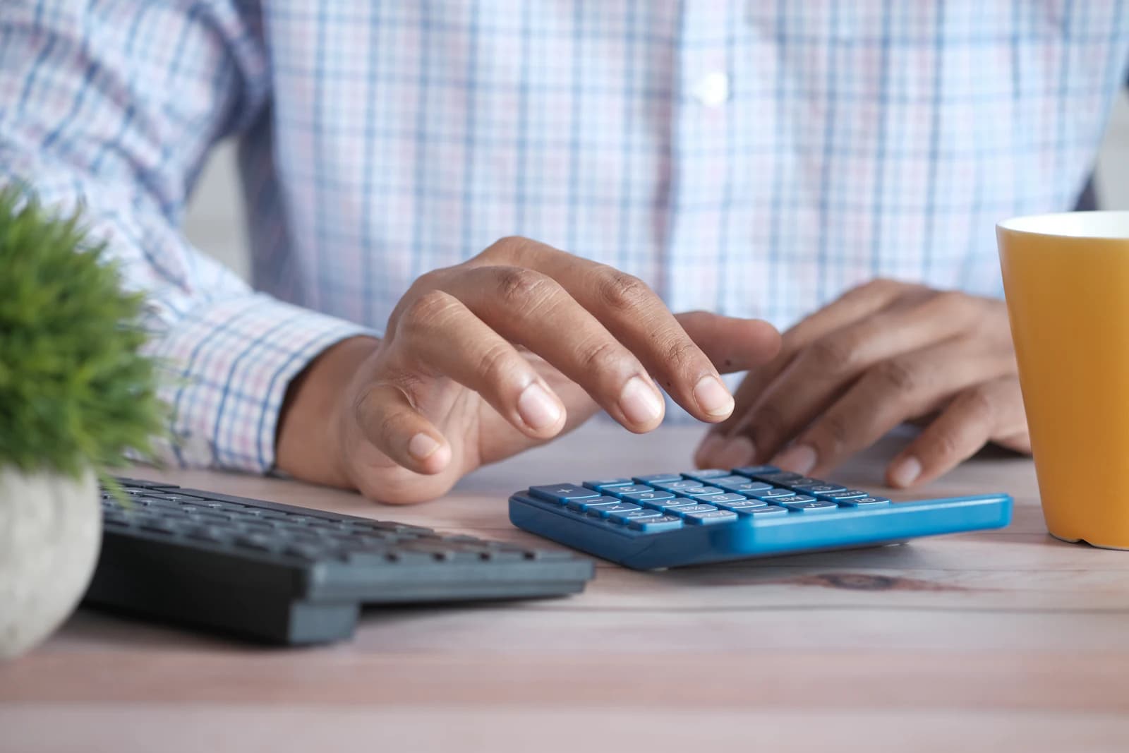 Pessoa conferindo valores numa calculadora