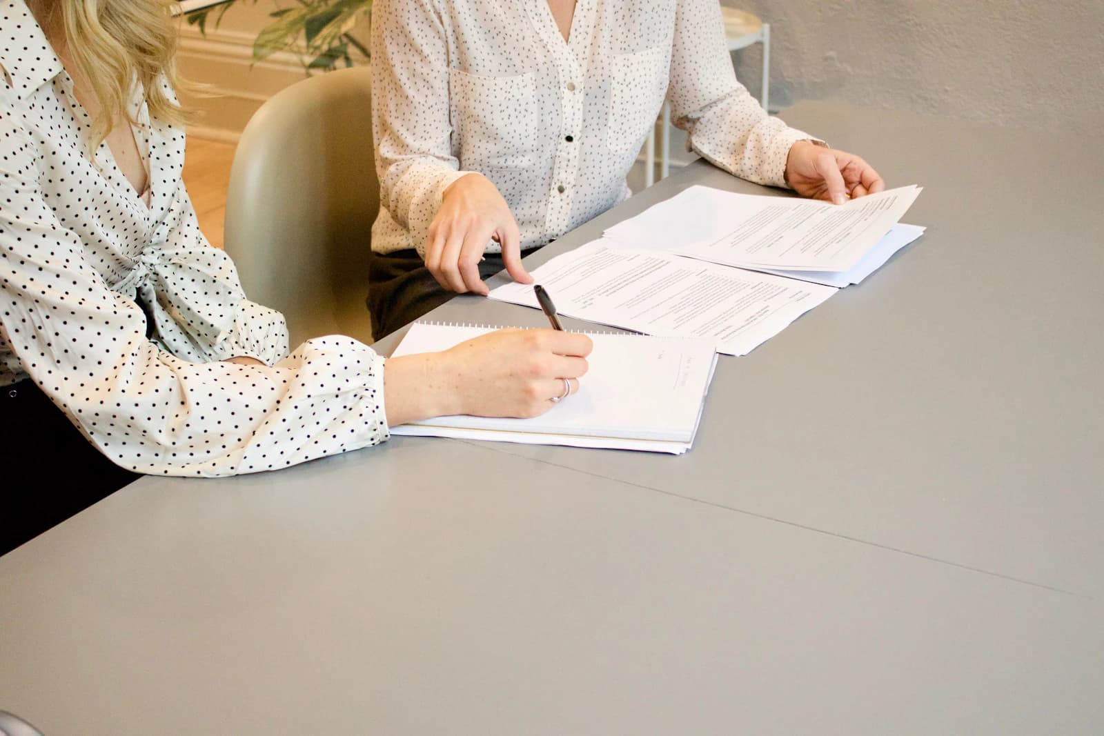 Duas pessoas revisando e assinando um contrato